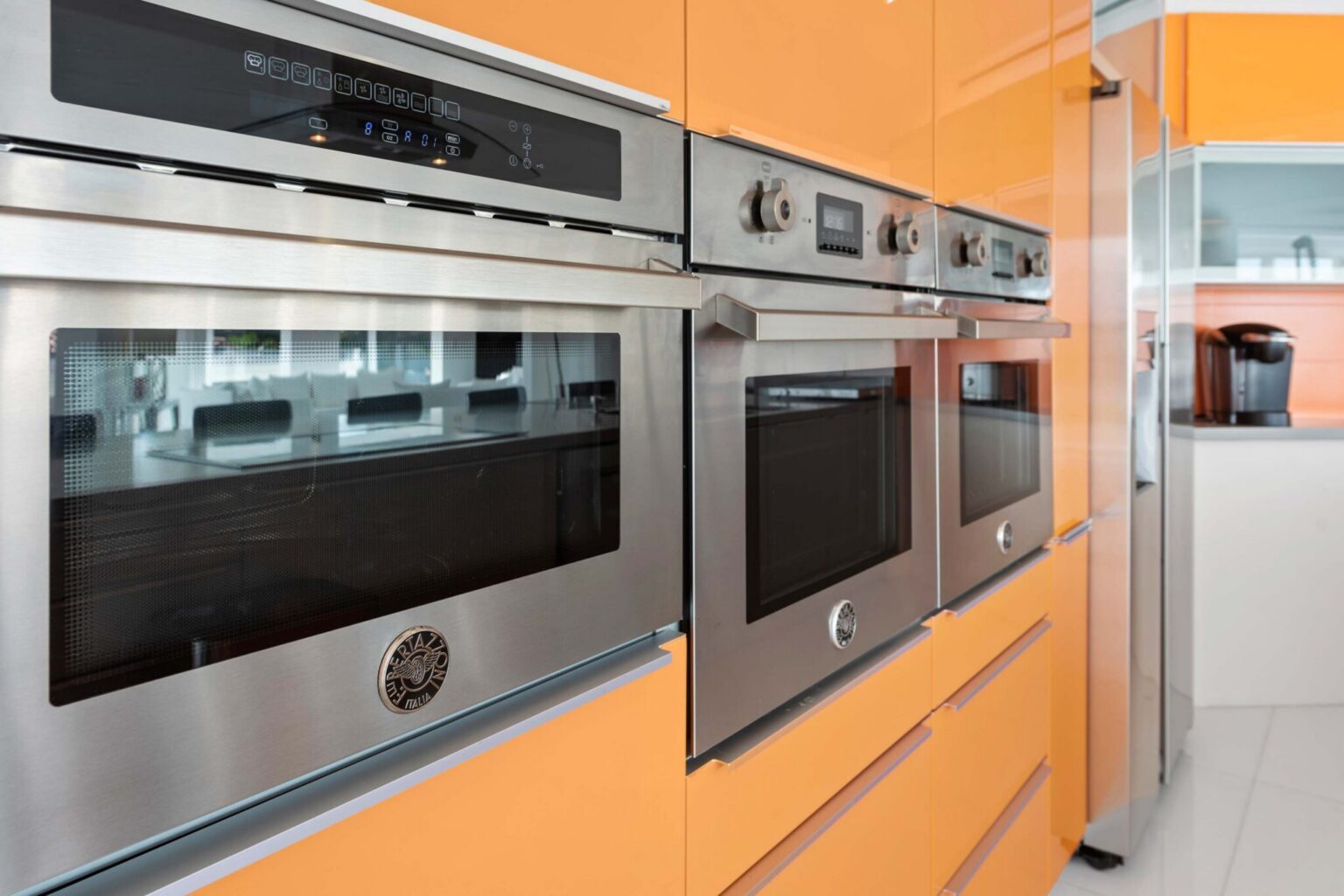 Built-in appliance wall featuring stainless steel double ovens, custom high-gloss cabinetry, integrated storage, modern finishes, and convenient access to the chef’s kitchen. Designed for meal preparation, entertaining, and extended stays.