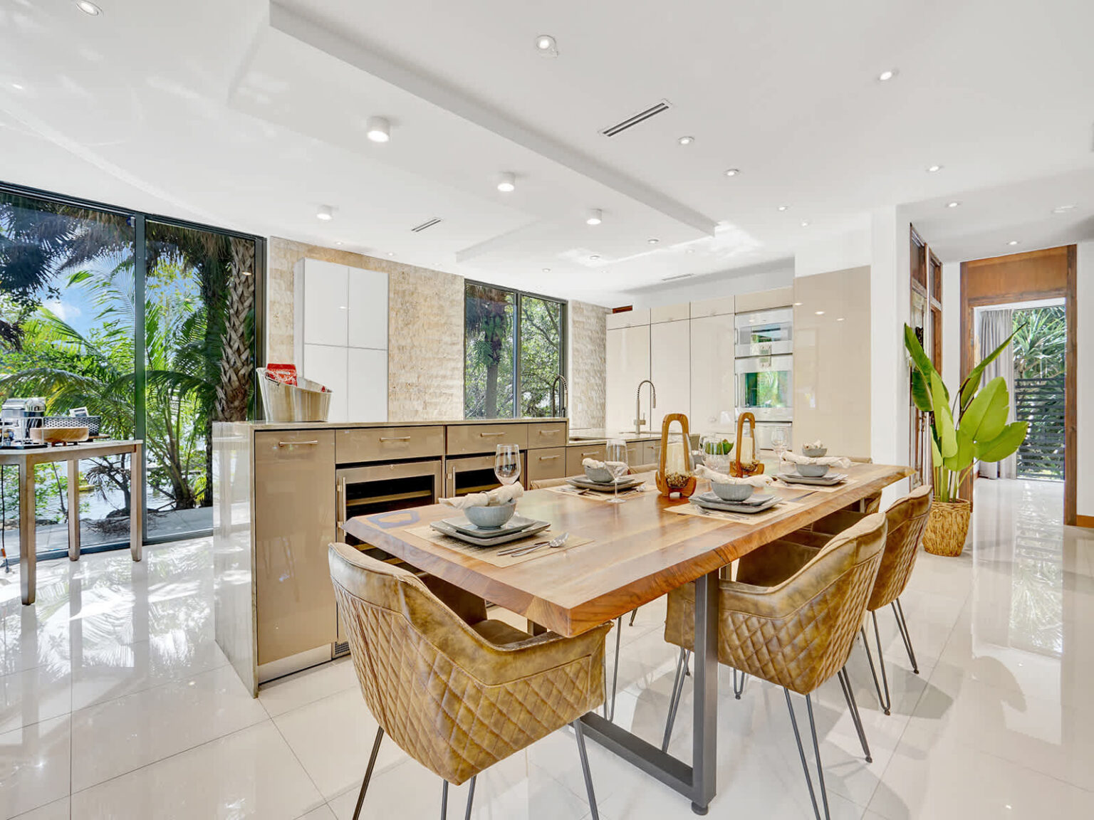 Modern dining area featuring a solid wood dining table, woven chairs, and an open-concept layout. Adjacent to the fully equipped kitchen, this bright space offers natural light, contemporary finishes, and seamless flow throughout the home.