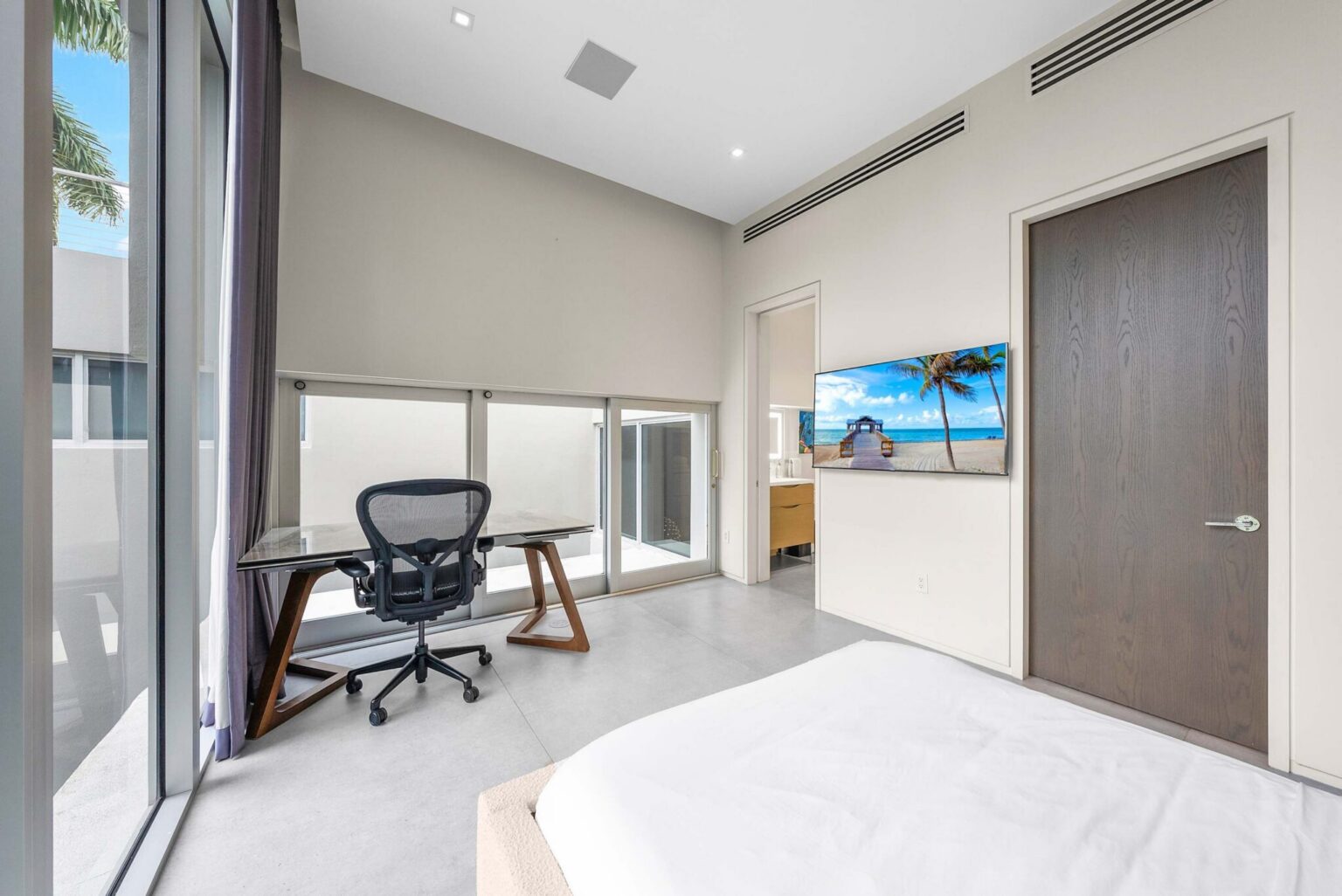 Luxury guest suite with dedicated workspace and floor-to-ceiling natural light.