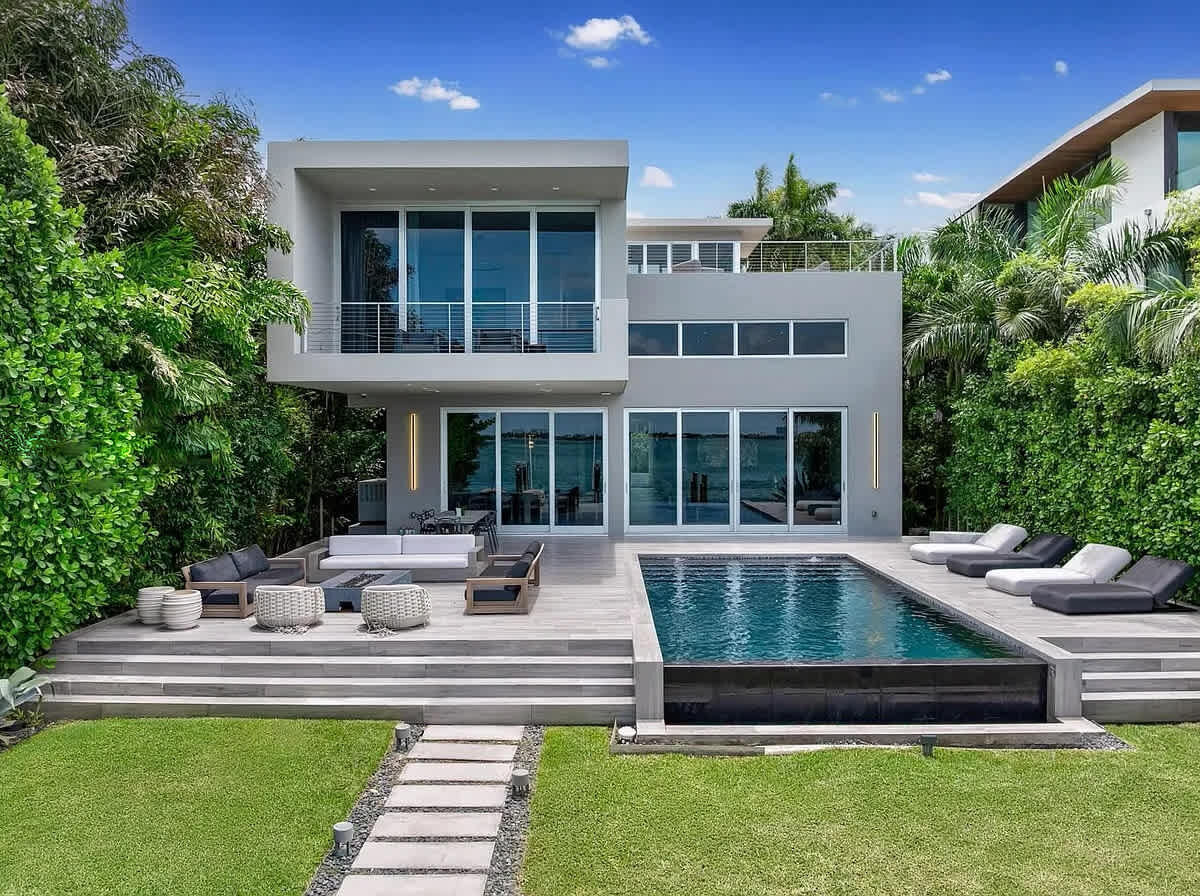 Modern luxury living with a stunning pool, expansive patio, premium loungers, and lush tropical surroundings.