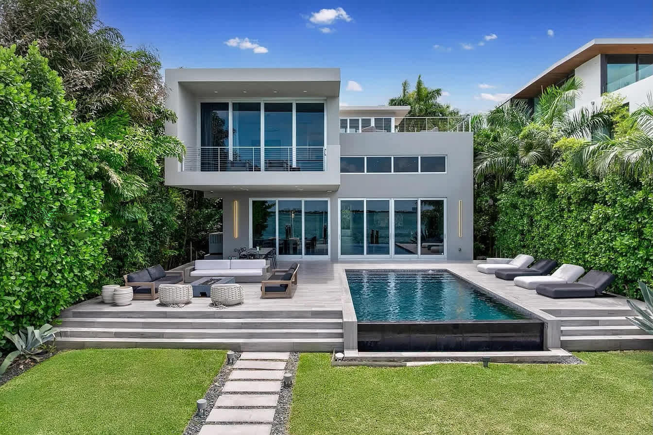 Modern luxury living with a stunning pool, expansive patio, premium loungers, and lush tropical surroundings.