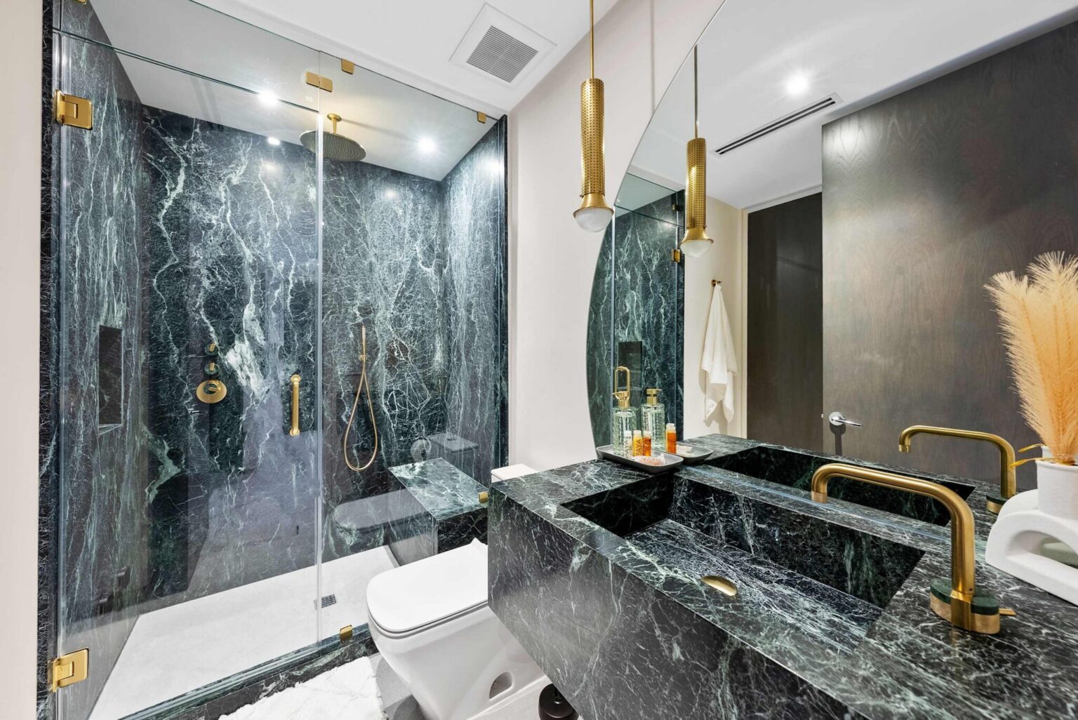Spa-inspired bathroom featuring a walk-in glass shower, marble-look finishes, custom vanity, and premium fixtures. Contemporary design elements, integrated lighting, and modern finishes create a functional and well-appointed ensuite space.
