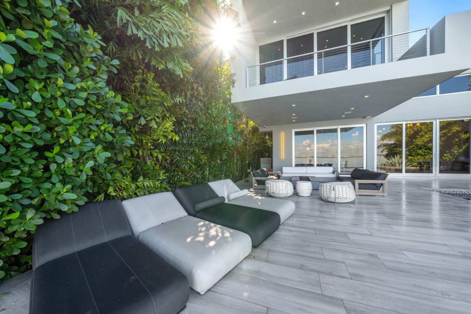 Poolside terrace featuring luxury sun loungers, tropical privacy landscaping, and expansive outdoor living space. Contemporary decking surrounds the private pool, creating a seamless setting for relaxation and outdoor entertaining.