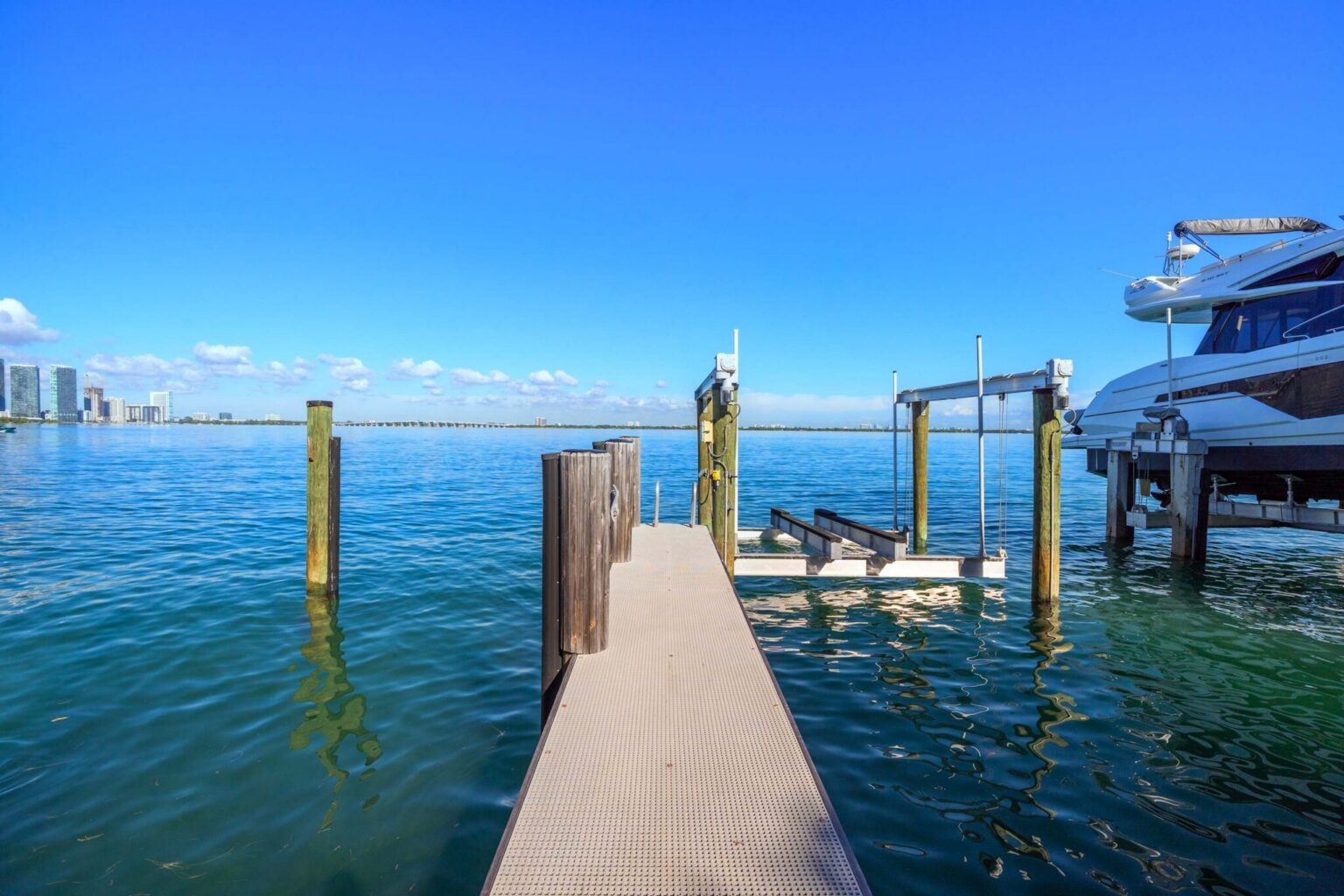 Boat dock with lift system and direct bay access, offering unobstructed water views and convenient waterfront access. Ideal for boating, fishing, and enjoying the property's prime waterfront location.