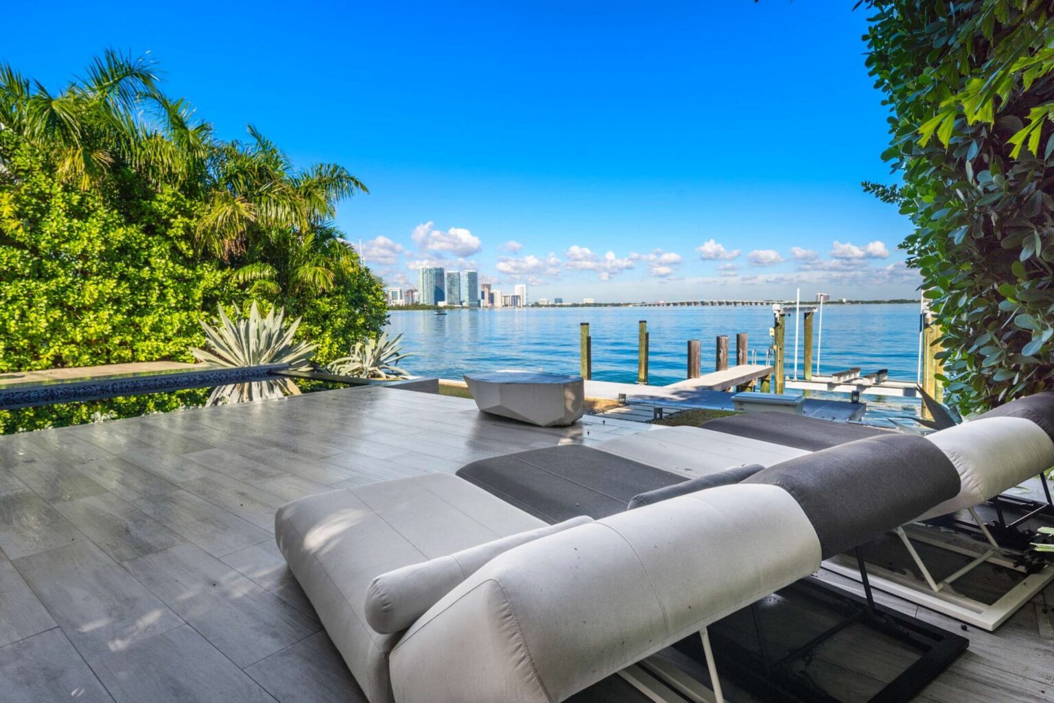 Waterfront sun deck with luxury loungers, panoramic bay views, and private dock access. Positioned along the shoreline, this outdoor retreat offers open-water vistas and direct access to the property's waterfront amenities.