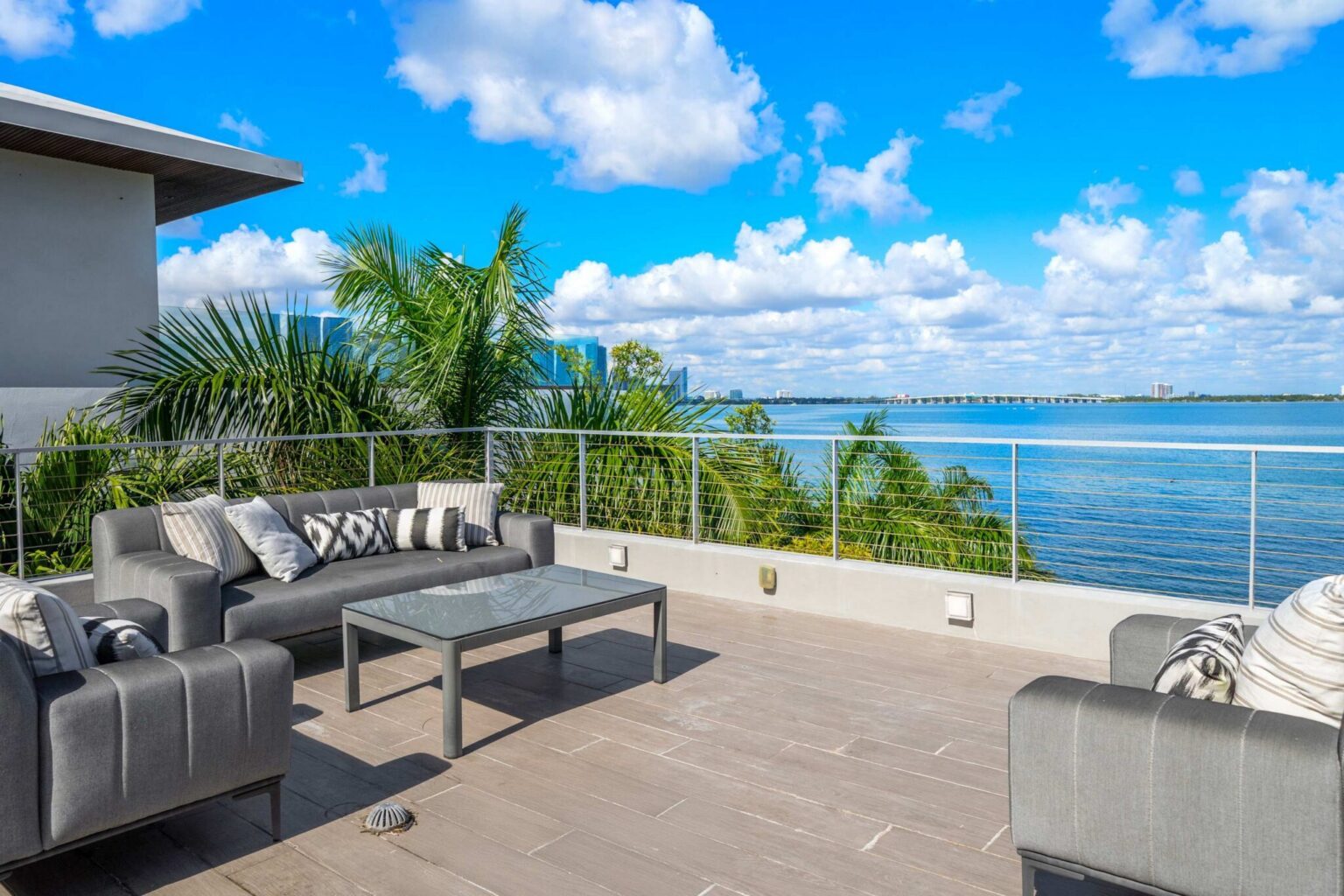 Private bayfront terrace showcasing designer furnishings and uninterrupted waterfront scenery.
