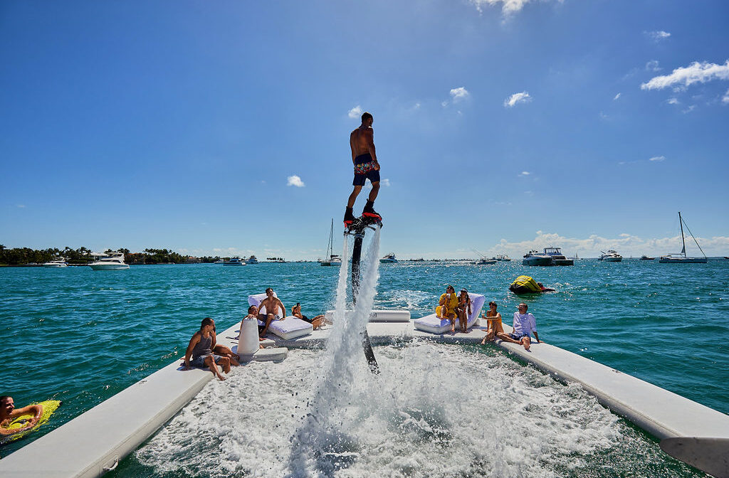 Group enjoying a flyboard experience on the water during a sunny Miami boat day.