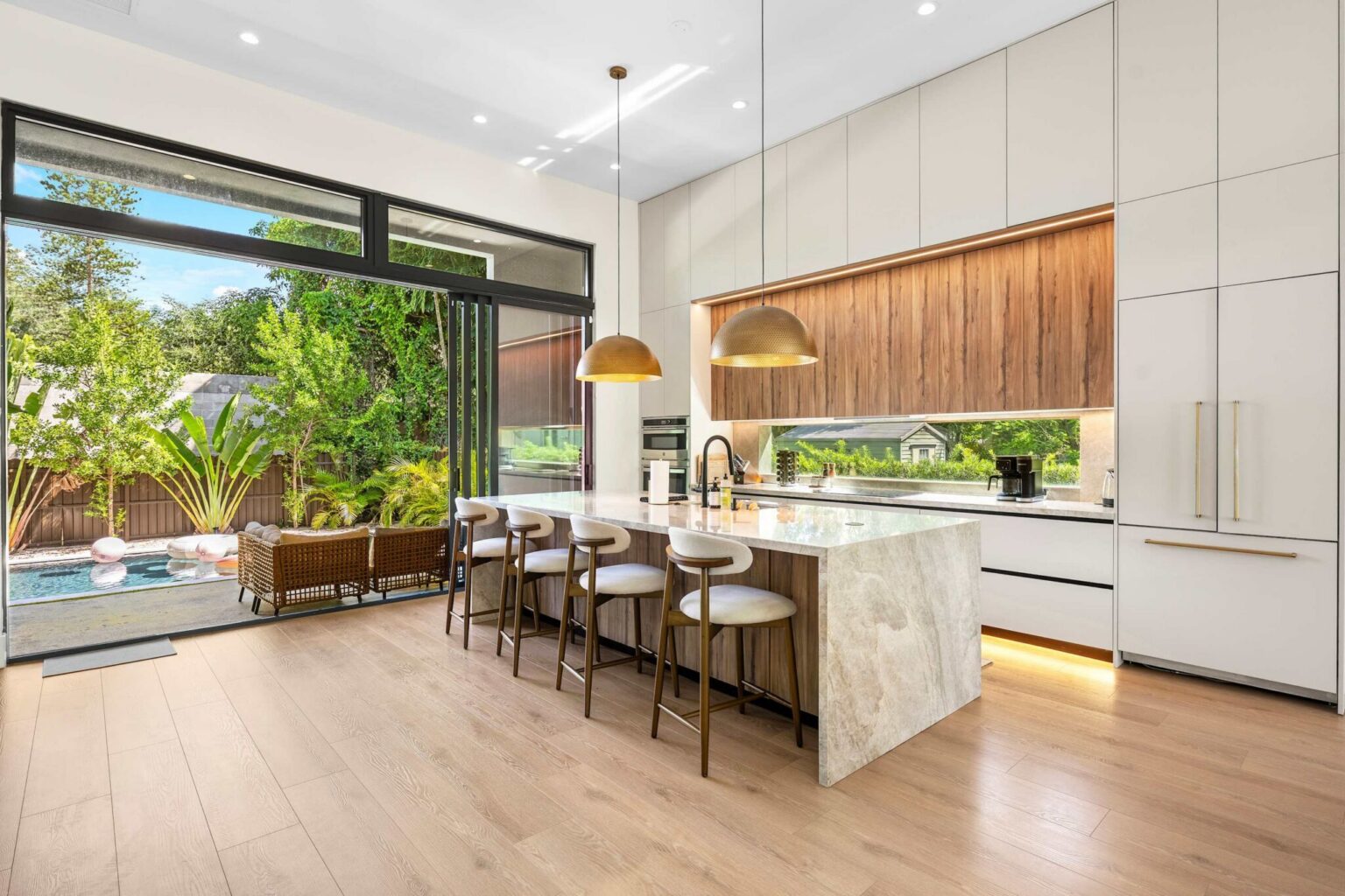 Marble island kitchen opening to the terrace and pool