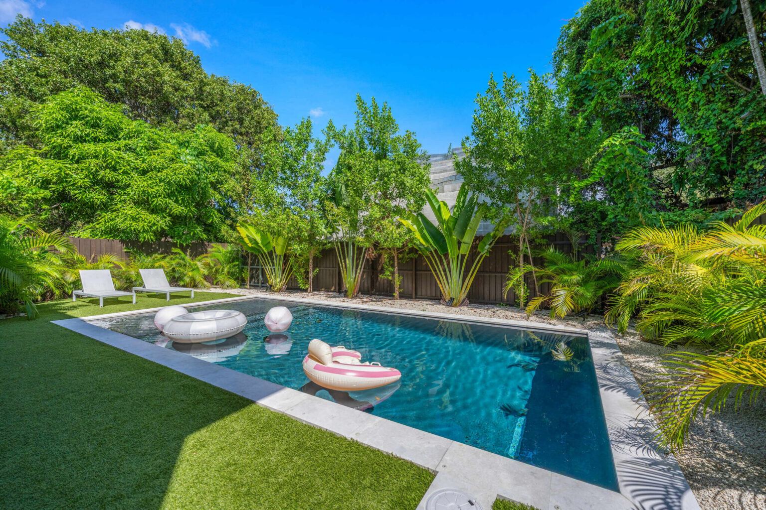 Private pool with floats, sun loungers and tropical landscaping