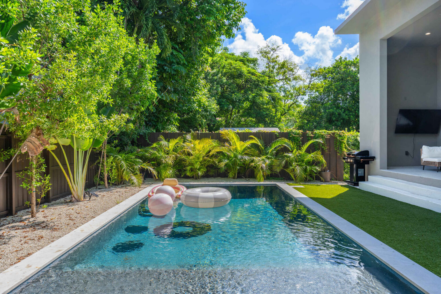 Private pool with floats against a lush tropical palm backdrop